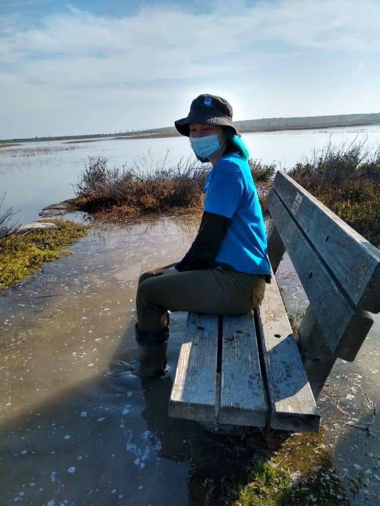 Person sitting on a bench that is flooded