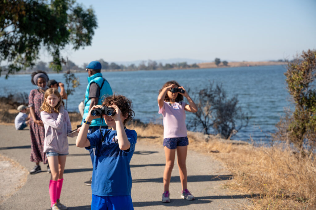 Group of kids looking through binoculars