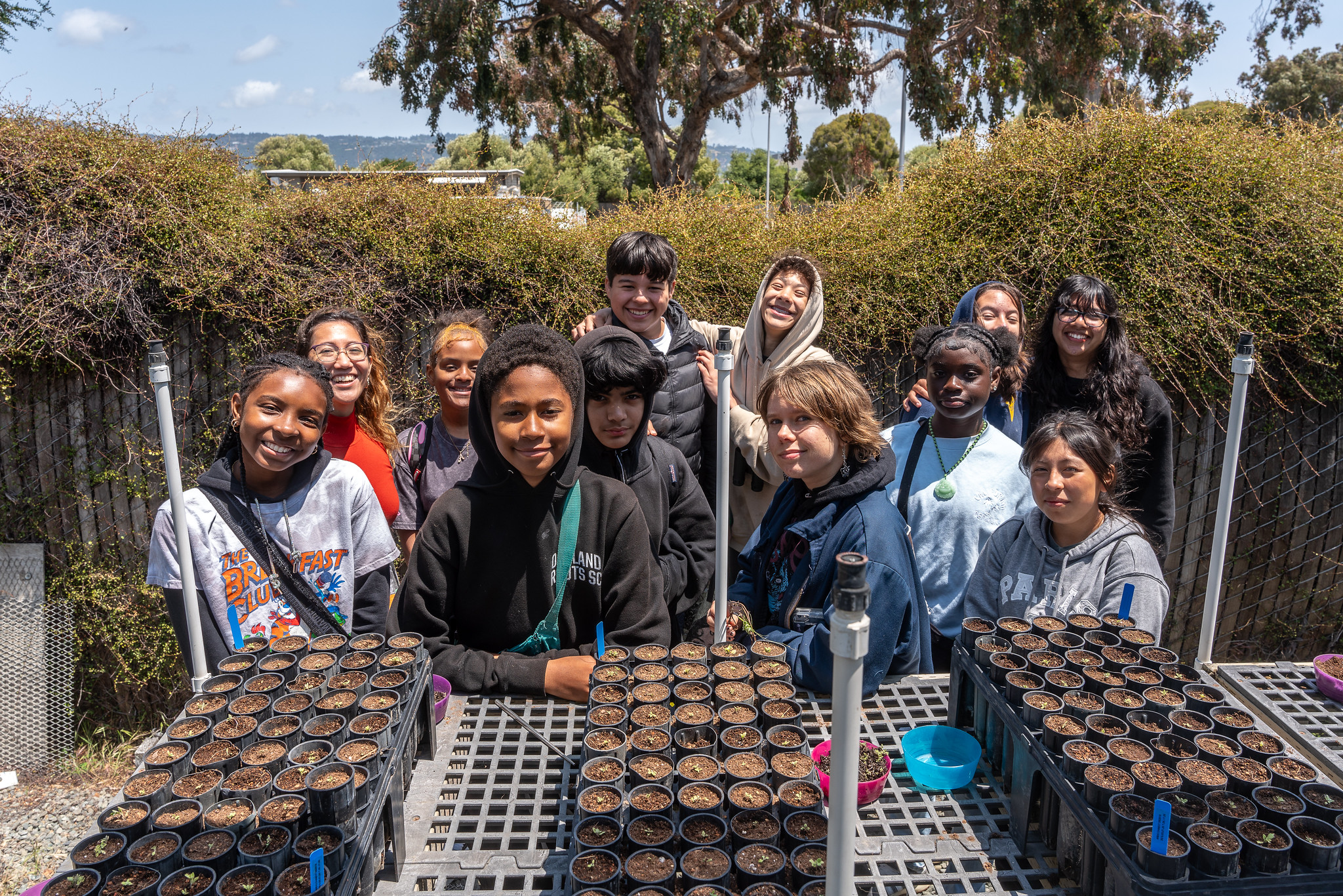 Children smiling in front of plant pots